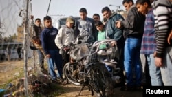 巴勒斯坦人觀看被以色列空襲損壞的摩托車