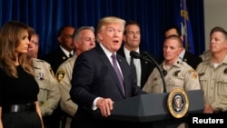 FILE - U.S. President Donald Trump speaks next to first lady Melania Trump after meeting with police at the Las Vegas Metropolitan Police Department in the wake of the mass shooting in Las Vegas, Nevada, Oct. 4, 2017.