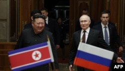 러시아 관영 스푸트니크 통신이 배포한 이 사진에서 김정은 북한 국무위원장(왼쪽)이 19일 평양에 도착한 블라디미르 푸틴 러시아 대통령을 환영하고 있다.