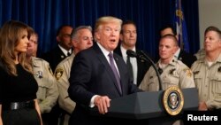 FILE - U.S. President Donald Trump speaks next to first lady Melania Trump after meeting with police at the Las Vegas Metropolitan Police Department in the wake of the mass shooting in Las Vegas, Nevada, Oct. 4, 2017.