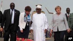 Le président malien Ibrahim Boubacar Keita (au centre) a accueilli la chancelière allemande Angela Merkel (à dr.) à l’arrivée de celle-ci à l'aéroport de Bamako, le 9 octobre 2016. 