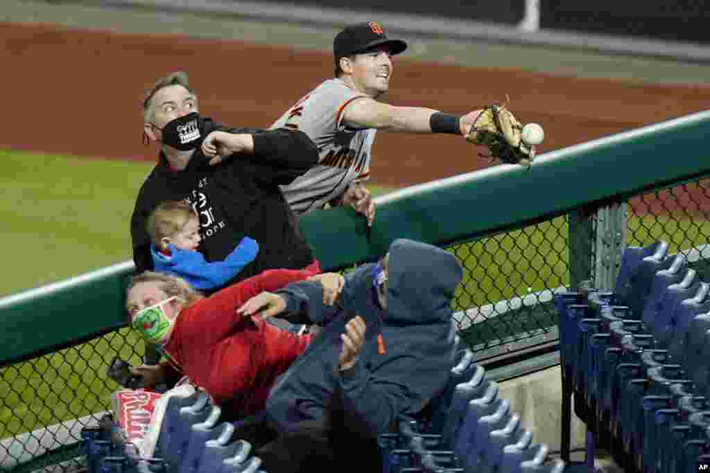 San Francisco Giants right fielder Mike Yastrzemski cannot reach a pop foul ball by Philadelphia Phillies&#39; Rhys Hoskins during the ninth inning of a baseball game, April 20, 2021, in Philadelphia, Pennsylvania.