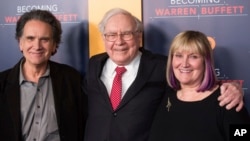 FILE - In this Jan. 19, 2017 photo, Peter Buffett, from left, Warren Buffett and Susie Buffett attend the world premiere screening of HBO's "Becoming Warren Buffett" at The Museum of Modern Art in New York.