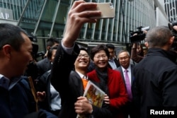 A man takes a selfie with Carrie Lam, chief executive-elect, a day after she was elected in Hong Kong, China, March 27, 2017.