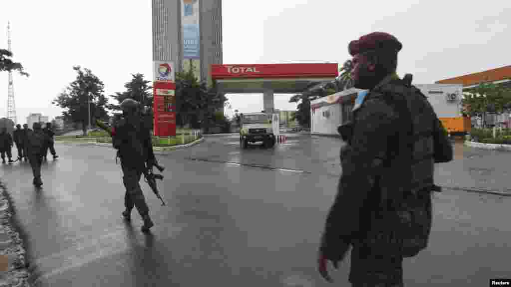 Congolese security forces secure the street near the state television headquarters in Kinshasa, Dec. 30, 2013.