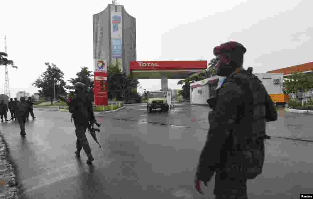 Forças congolesas patrulham a rua junto à sede estação televisiva do Estado, Kinshasa, Dez. 30, 2013. 