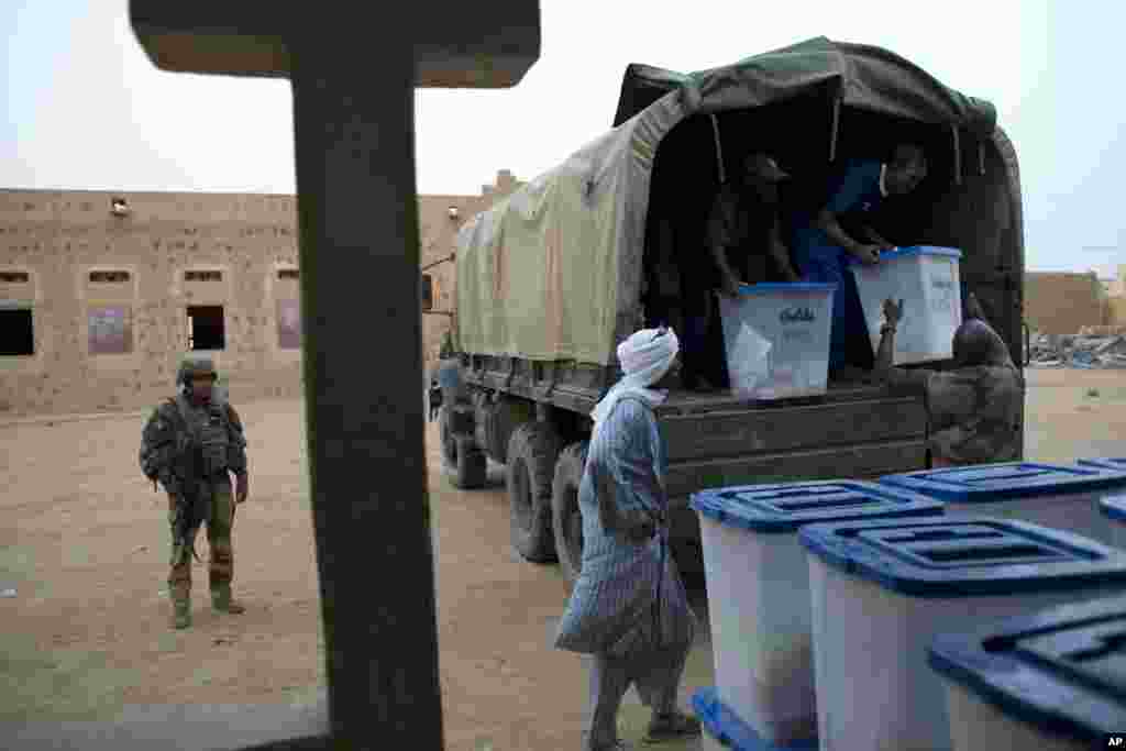 A French soldier stands guard as election workers unload ballot boxes containing election materials at the main polling station in Kidal, Mali, July 28, 2013.&nbsp;