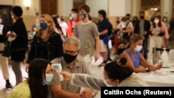 Jane Hassebroek sedang menjalani pemeriksaan suhu tubuh sebelum vaksinasi COVID-19 di American Museum of Natural History, di Manhattan, Kota New York, 14 Mei 2021. (Foto: Caitlin Ochs/Reuters)