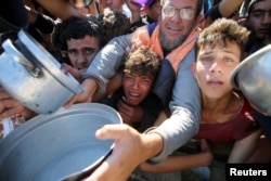 Warga Palestina berkumpul untuk menerima makanan dari dapur amal di Khan Younis, Gaza Selatan, 19 November 2024. (Foto: Reuters)