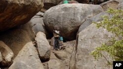 Children stand outside a cave shelter in Tess village in the rebel-held territory of the Nuba Mountains in South Kordofan May 2, 2012. 