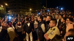 Police officers, right, that were being held by indigenous groups wait to be handed over to representatives of the United Nations in Quito, Oct. 10, 2019.