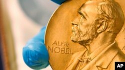 FILE - A national employee shows the gold Nobel Prize medal. 