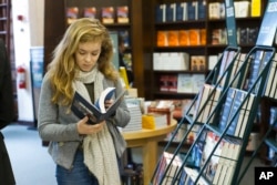 Rose Cronin-Jackman looks at a copy of "A Higher Loyalty" by former FBI Director James Comey, April 17, 2018, at a Barnes & Noble bookstore in New York.