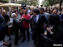 Sacked Catalan President Carles Puigdemont (C) walks with his wife Marcela Topor (R) as he greets a supporter during a walkabout the day after the Catalan regional parliament declared independence from Spain in Girona, Spain, October 28, 2017.