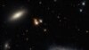 A lenticular galaxy, L, and the spiral galaxy named UGC 2665, R, lie approximately 350 million light-years from Earth. They both form part of the enormous Perseus galaxy cluster.