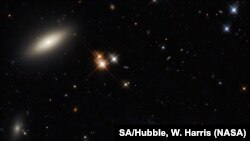 A lenticular galaxy, L, and the spiral galaxy named UGC 2665, R, lie approximately 350 million light-years from Earth. They both form part of the enormous Perseus galaxy cluster.