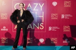 Actress Fiona Xie poses for photographers as she arrives for the red carpet screening of the movie "Crazy Rich Asians," Aug. 21, 2018, in Singapore.