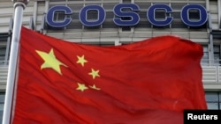 A Chinese national flag flies in front of COSCO's headquarters in Beijing, August 26, 2010. 