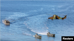 Las naves de aterrizaje y un helicóptero se ven durante el Ejercicio Trident Juncture de la OTAN, en la costa de Trondheim, Noruega, 30 de octubre de 2018.