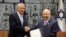 Israeli President Reuven Rivlin, right, hands a mandate to form new government to Blue and White Party leader Benny Gantz, in Jerusalem, Oct. 23, 2019.