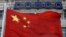 A Chinese national flag flies in front of COSCO's headquarters in Beijing August 26, 2010. 