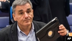 FILE - Greece's Finance Minister Euclid Tsakalotos prepares for a Eurogroup meeting at the EU Council in Luxembourg, Oct. 10, 2016. 