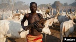 一名南蘇丹丁卡部落男子手持AK步槍守護牧民營地。