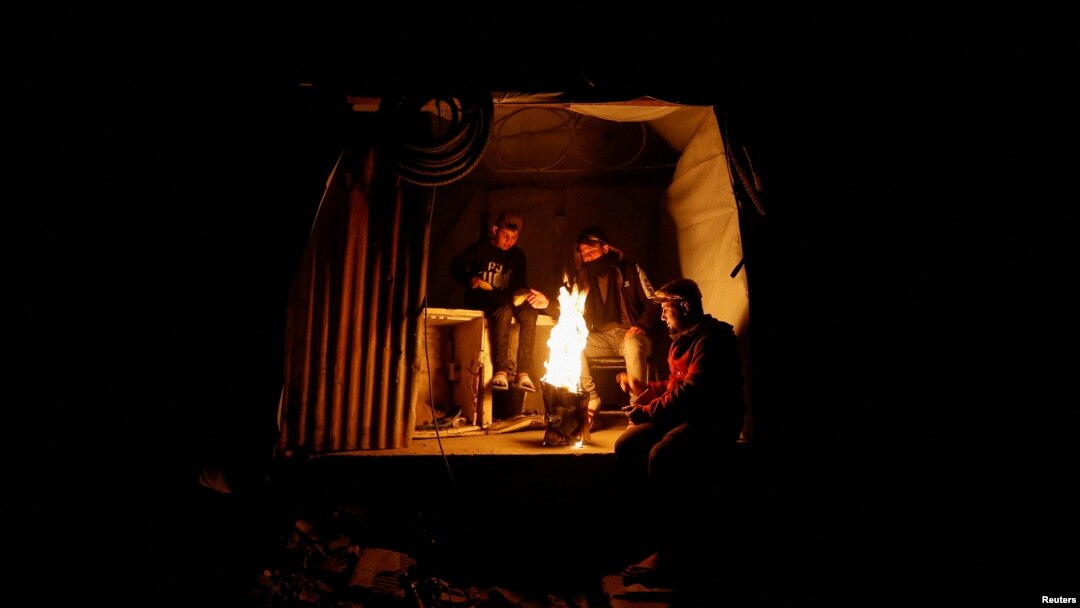 Palestinos se reúnen alrededor de una fogata, en medio de un alto el fuego entre Israel y Hamás, en el campo de refugiados de Jabalia, en el norte de la Franja de Gaza, el 26 de febrero de 2025.