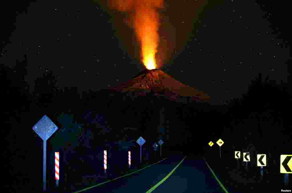 Smoke and lava spew from the Villarrica volcano, as seen from Pucon town, in the south of Santiago, Chile. Authorities have restricted access to the area within 5 kilometers (3 miles) of the crater and have put the area under an orange alert due to the volcano's heightened unrest and increased likelihood of eruption.