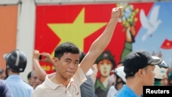 A protester gestures as he marches during an anti-China protest in Vietnam's southern Ho Chi Minh city May 18, 2014. Vietnam flooded major cities with police to avert anti-China protests on Sunday in the wake of rare and deadly rioting in industrial parks