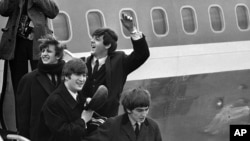 This Feb. 7, 1964 file photo shows The Beatles, from left, Ringo Starr, John Lennon, Paul McCartney and George Harrison, arriving in New York at John F. Kennedy airport.