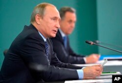 Russian President Vladimir Putin, left, and Sports Minister Vitaly Mutko, attend their late-night meeting with the heads of Russia's sports federations in the Black Sea resort of Sochi, Russia, Wednesday, Nov. 11, 2015.