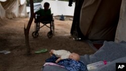 Ahmed Khalil Isa, 15 ans, adolescent syrien handicapé, est assis dans son fauteuil roulant devant la tente de sa famille au camp de réfugiés de Ritsona, au nord d'Athènes, Grèce, 19 septembre 2016.