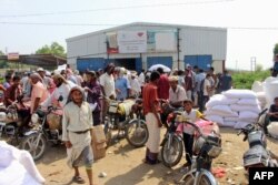 FILE - Yemenis displaced from the port city of Hodeida receive humanitarian aid donated by the World Food Program in the northern province of Hajjah, Sept. 25, 2018.