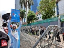 Para polisi dikerahkan untuk mengamankan Kedutaan Besar Cina di Jakarta, pada aksi unjuk rasa membela Muslim Uighur Jumat 27/12. (VOA/Fathiyah).