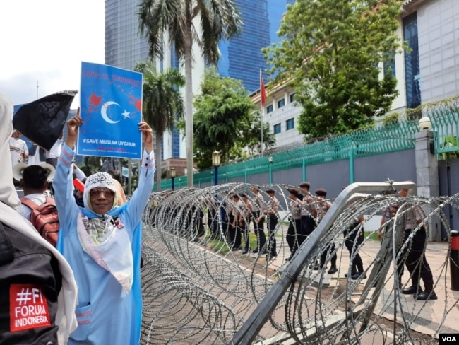 Para polisi dikerahkan untuk mengamankan Kedutaan Besar Cina di Jakarta, pada aksi unjuk rasa membela Muslim Uighur Jumat 27/12. (VOA/Fathiyah).