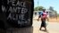 A woman walks past a message of peace in Kibera slum in the capital Nairobi, February 28, 2013.