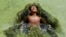 A boy jumps in a pond covered with algae at Kirtipur on the outskirts of Kathmandu.