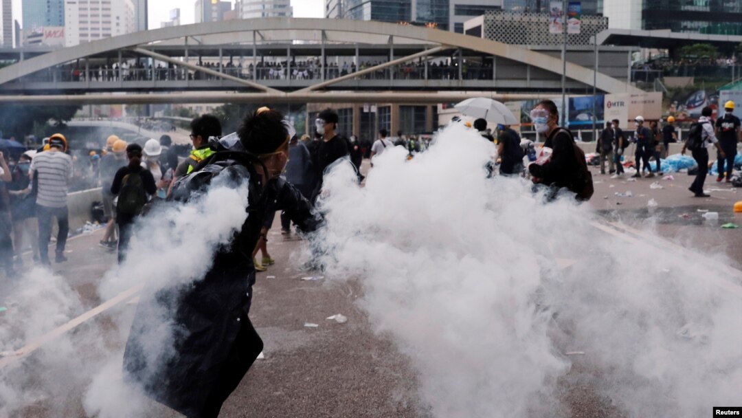 Demonstran melemparkan kaleng gas air mata pada aksi protes RUU Ekstradisi massal di Hong Kong, Rabu (12/6). 