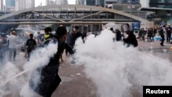 Demonstran melemparkan kaleng gas air mata pada aksi protes RUU Ekstradisi massal di Hong Kong, Rabu (12/6). 