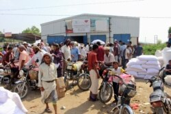 FILE - Yemenis displaced from the port city of Hodeida receive humanitarian aid donated by the World Food Programme (WFP) in the northern province of Hajjah, Sept. 25, 2018.