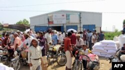 FILE - Yemenis displaced from the port city of Hodeida receive humanitarian aid donated by the World Food Programme (WFP) in the northern province of Hajjah, Sept. 25, 2018.