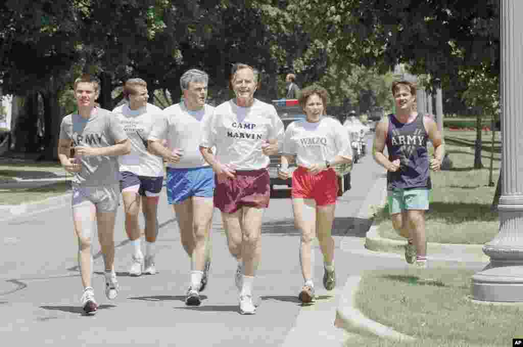 President George H.W. Bush, along with unidentified staff members and secret service agents, takes a morning run, at Ft. McNair in Washington, August 5, 1991.