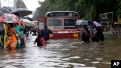 People walk through a waterlogged street following heavy rains in Mumbai, India, Aug. 29, 2017. 