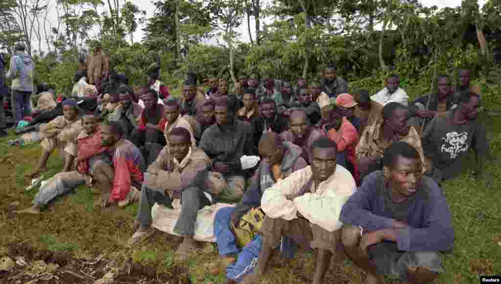 Suspected M23 rebel fighters sit in a group after surrendering to the Congolese army in Chanzo village near the eastern town of Goma, Nov. 5, 2013.