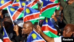 Mourners hold Namibian flags during the burial of Sam Nujoma, who became Namibia's first democratically elected president, at Namibia's Heroes' Acre, near the capital Windhoek, March 1, 2025.