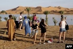 Tourists visit Yasmina lake, a seasonal lake in the village of Merzouga in the Sahara desert in southeastern Morocco, Oct. 20, 2024.