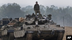 Binh sĩ Israel đứng trên một chiếc xe tăng tại khu vực gần biên giới Israel-Dải Gaza, ngày 20/11/2012.