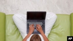 High angle view of a young woman using laptop while sitting on sofa