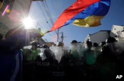 Un manifestante ondea la bandera de Ecuador durante protestas contra cambios constitucionales. Dic. 3 de 2015.